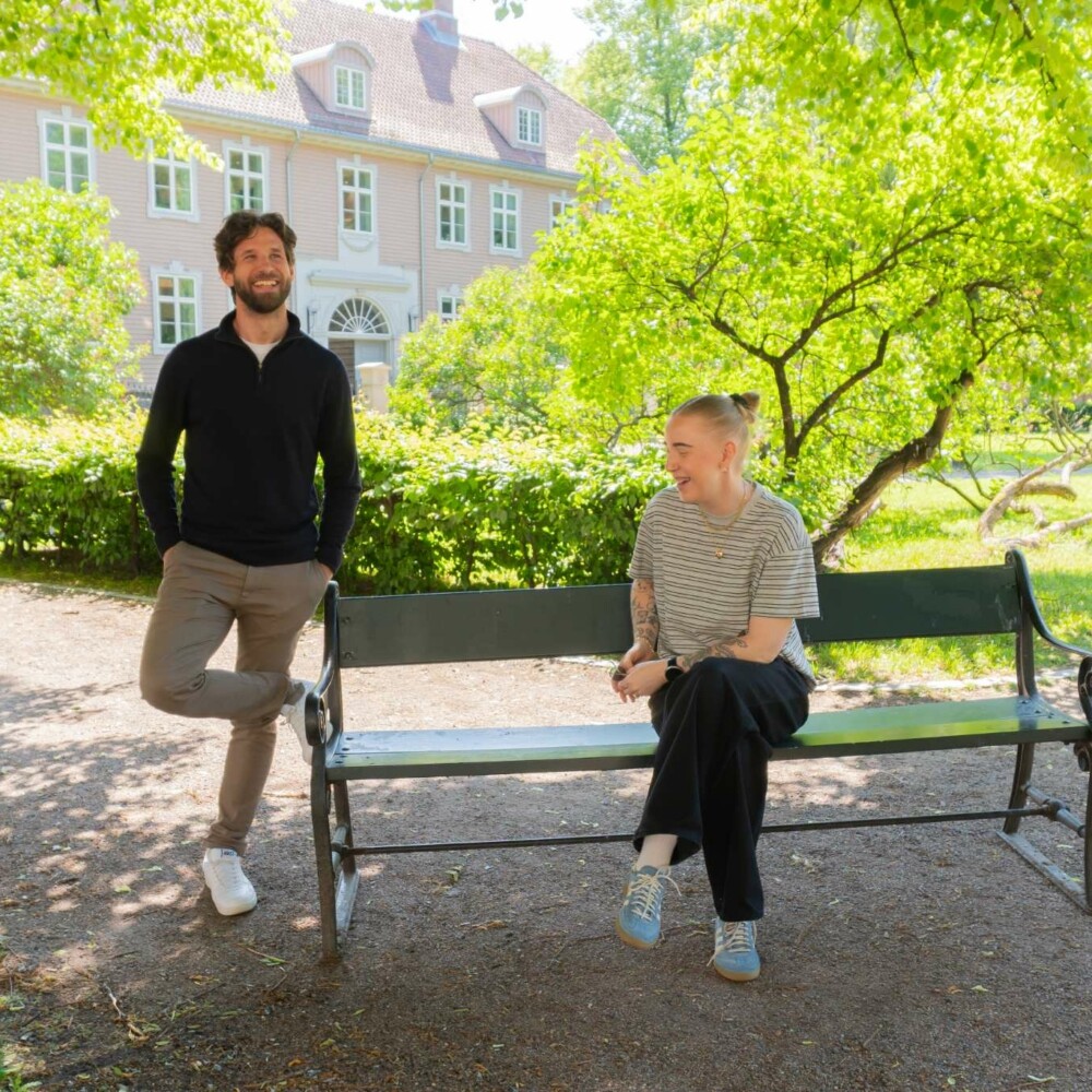 To personer som står i en park og ler og har det gøy