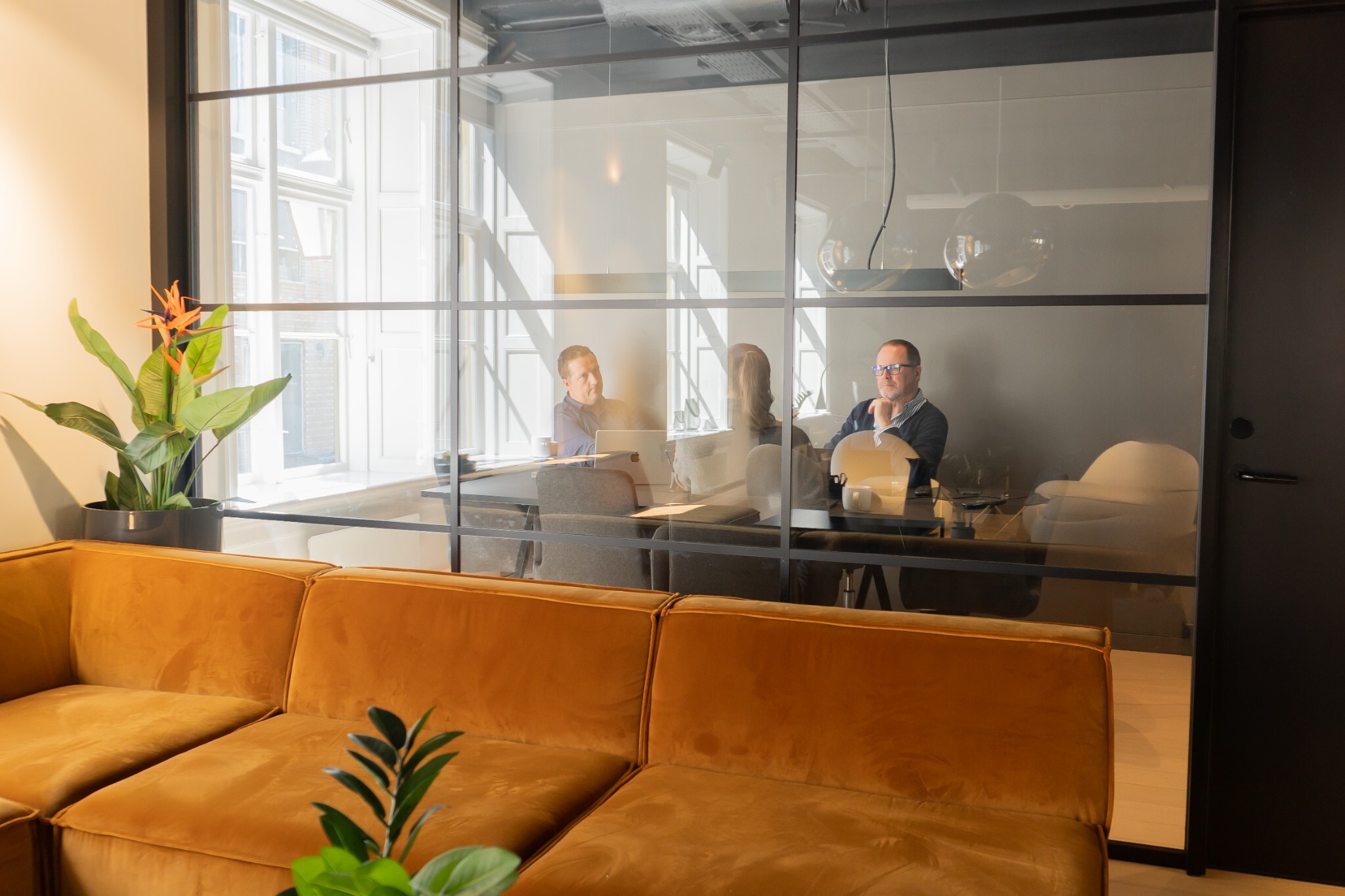 Ansatte sitter og jobber i et møterom