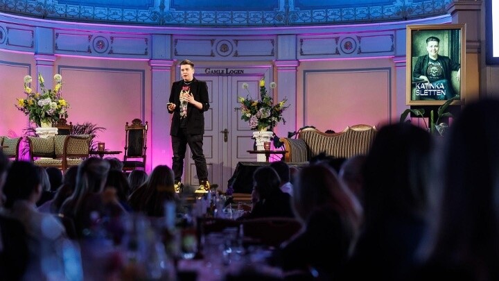 Kathinka Sletten holder foredrag på en scene foran publikum.