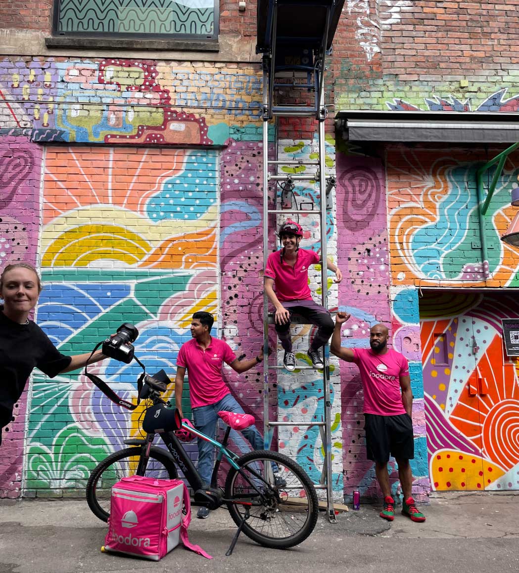 Tre foodora bud står oppstilt for å ta et kreativt bilde under produksjonsdagen.